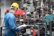 © iStocker - engineer checking metal component at machine receptacle in factory