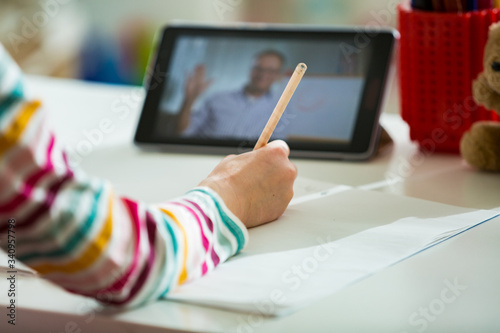 Fotografía Primary school student having video conference call with teacher using webcam