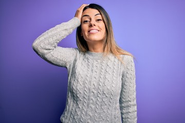 Sticker - Young beautiful woman wearing casual sweater standing over isolated purple background confuse and wonder about question. Uncertain with doubt, thinking with hand on head. Pensive concept.