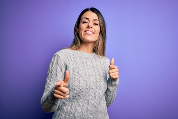 Canvas Print - Young beautiful woman wearing casual sweater standing over isolated purple background pointing fingers to camera with happy and funny face. Good energy and vibes.