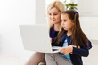 © Angelov - Beautiful woman helping her daughter doing her homework in a kitchen