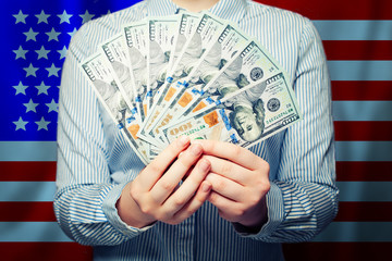 Wall Mural - Hands holding cash money us dollars banknote on American flag background