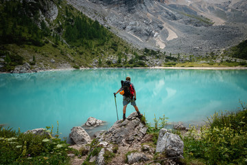 Wall Mural - Tourist posing for a photo against the background of the beautiful Lago di Sorapis lake in the Italian Dolomites