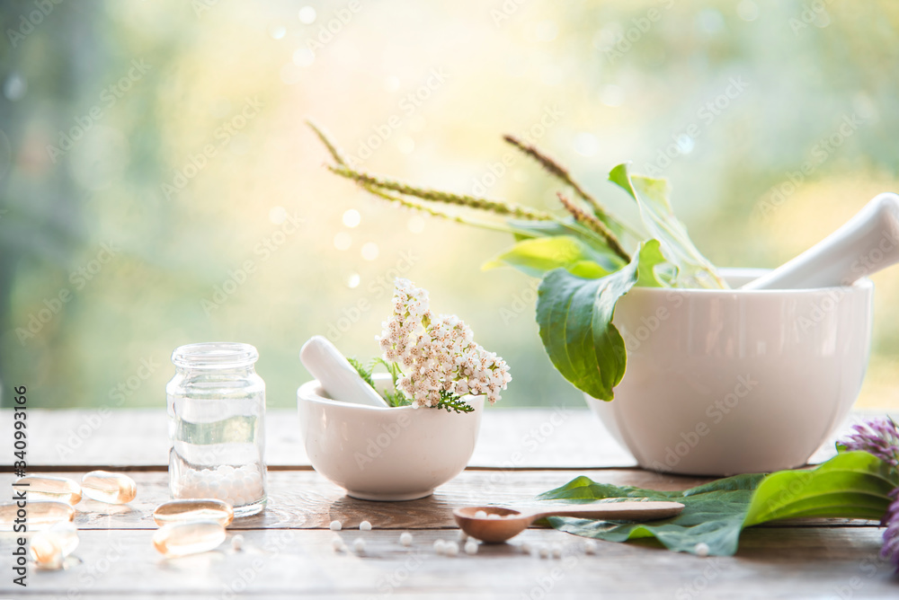 homeopathic granules, medicinal herbs on a natural wooden table on a natural background. alternative medicine and homeopathy - obrazy, fototapety, plakaty 