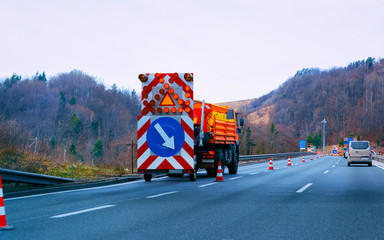 Wall Mural - Truck carrying arrow down left reflective direction road sign reflex