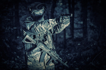 Wall Mural - Portrait of a soldier in the forest. He shoots a pistol. Border Protection Concept.