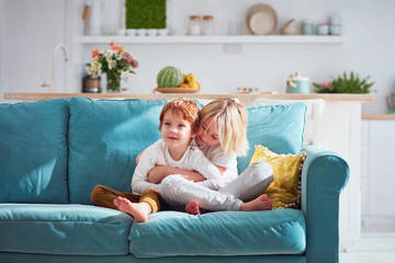 Wall Mural - cute happy brothers sitting together on sofa at home. Kids relations