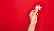 © Krakenimages.com - Beautiful hand of man holding piece of puzzle over isolated red background