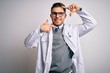 © Krakenimages.com - Young doctor man with blue eyes wearing medical coat and stethoscope over isolated background smiling making frame with hands and fingers with happy face. Creativity and photography concept.