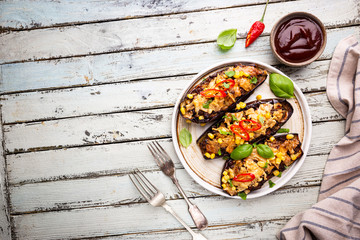 Poster - Baked aubergines boats, stuffed with minced meat, tomatoes, corn, garlic and cheese in white plate, top view