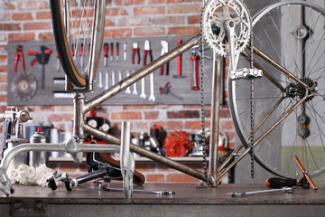 Wall Mural - vintage bicycle in garage workshop on the workbench with tools, diy concept