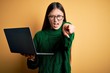 Young asian business woman wearing glasses and working using computer laptop pointing displeased and frustrated to the camera, angry and furious with you