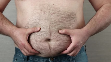 fat man with big belly showing his huge abdomen. Health care and overeating problem concept