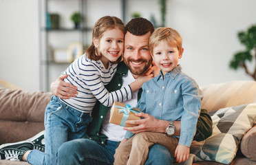 Wall Mural - little siblings congratulating happy father at home.