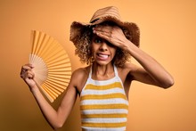 African American Tourist Woman With Curly On Vacation Wearing Summer Hat Using Hand Fan Stressed With Hand On Head, Shocked With Shame And Surprise Face, Angry And Frustrated. Fear And Upset 