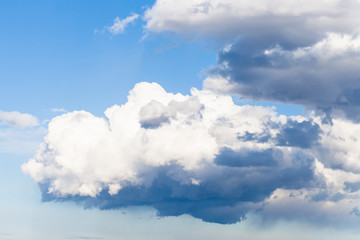 Wall Mural - low large white rainy clouds in blue sky