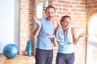 © Krakenimages.com - Middle age sporty couple standing before do exercise at gym clueless and confused expression with arms and hands raised. Doubt concept.