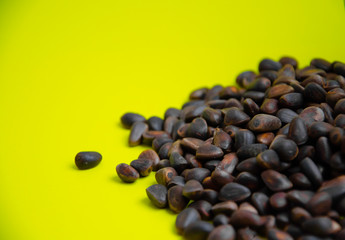 Pine nuts lie on a yellow background healthy diet concept