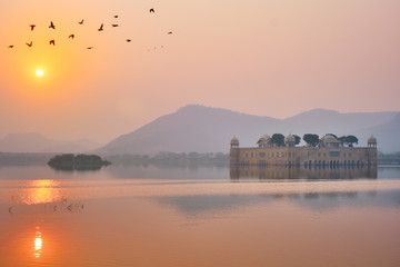 Fototapete - Tranquil morning at famous indian tourist landmark Jal Mahal (Water Palace) at sunrise in Jaipur. Ducks and birds around enjoy the serene morning. Jaipur, Rajasthan, India