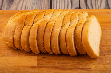 Sliced loaf of wheat bread on a wooden cutting Board. Close up.