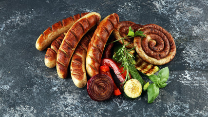 Wall Mural - Assorted delicious grilled meat with vegetable on a barbecue with grilled sausages and vegetables on table