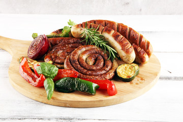 Wall Mural - Assorted delicious grilled meat with vegetable on a barbecue with grilled sausages and vegetables on table