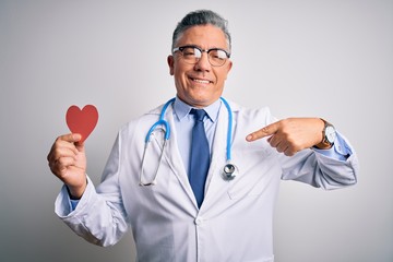 Poster - Middle age handsome grey-haired doctor man holding heart of red paper with surprise face pointing finger to himself