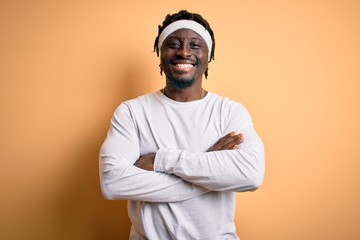 Poster - Young african american man doing sport wearing sportswer over isolated yellow background happy face smiling with crossed arms looking at the camera. Positive person.