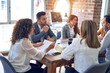 © Krakenimages.com - Group of business workers working together. Sitting on desk speaking at the office