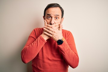 Wall Mural - Middle age hoary man wearing casual orange sweater standing over isolated white background shocked covering mouth with hands for mistake. Secret concept.