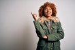 © Krakenimages.com - Young beautiful African American woman with curly hair wearing green casual winter coat with a big smile on face, pointing with hand and finger to the side looking at the camera.