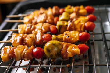 BBQ grill with a variety of meats, complete with tomatoes and bell peppers.