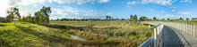 Panoramic View Of Skeleton Waterholes Creek With A Wooden Boardwalk Leads To Some Suburban Houses In Distance. Truganina, Melbourne, VIC Australia.