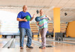 © Pixel-Shot - Senior couple playing bowling in club