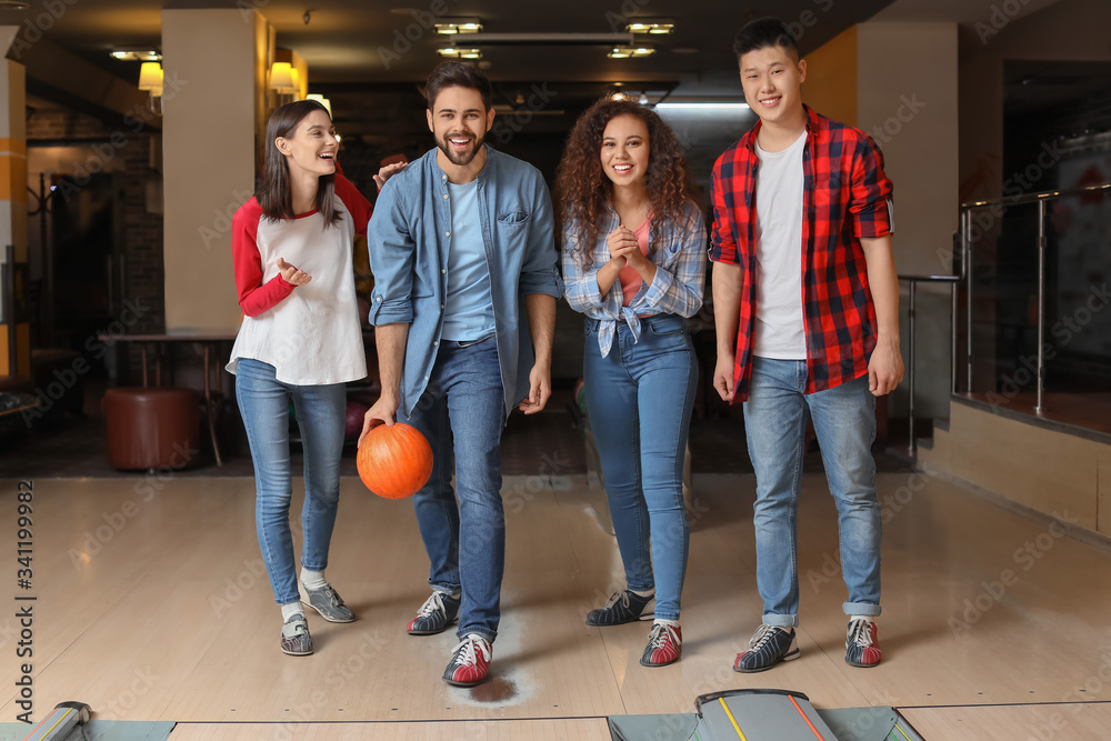 Friends playing bowling in club
