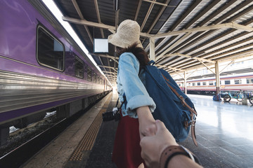 Romance young Asian woman holding boyfriend hands follow her at train station. Romantic and travel in summer vacation concept.