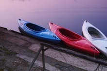 High Angle View Of Kayaks Moored On Water By Lakeshore