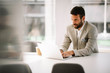 © JustLife - Businessman in office. Handsome man working on lap top.