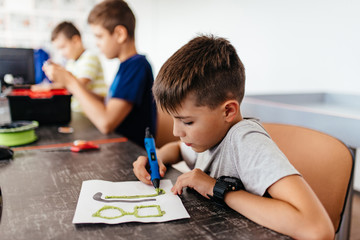 Two boys creating with 3d printing pens