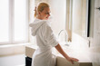 © JustLife - Beautiful woman wearing a bathrobe. Young happy woman enjoing in hotelroom.