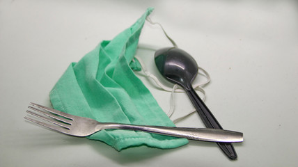 cutlery, spoons and forks given a green health mask, Unfocused, Noise, Blurry selective focus image