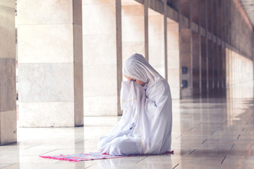 Wall Mural - Young muslim woman praying in the mosque