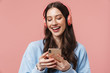 © Drobot Dean - Image of delighted woman laughing while using headphones and cellphone