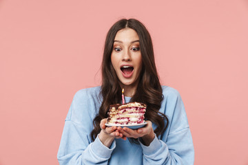 Wall Mural - Image of attractive young woman making wish while holding birthday cake