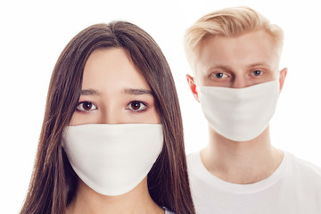 Wall Mural - Couple of young people in protective face masks isolated on white.