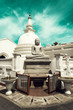 Biała buddyjska świątynia z posągiem Buddy oraz stupą na tle niebieskiego nieba.