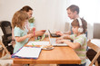 © ulza - family Mom, dad and two  kids Sitting at the table all together. Children learn onlay from home. work from home with kids. quarantin. Home office.