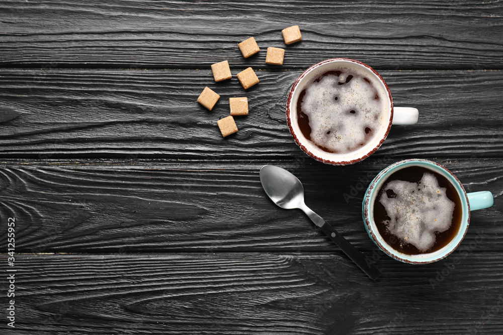 Cups of coffee with sugar on wooden background