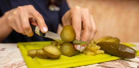 Wall Mural - The girl cuts pickles with a knife