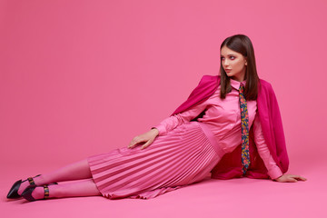 Wall Mural - Fashion model in magenta jacket, pink skirt and shirt.